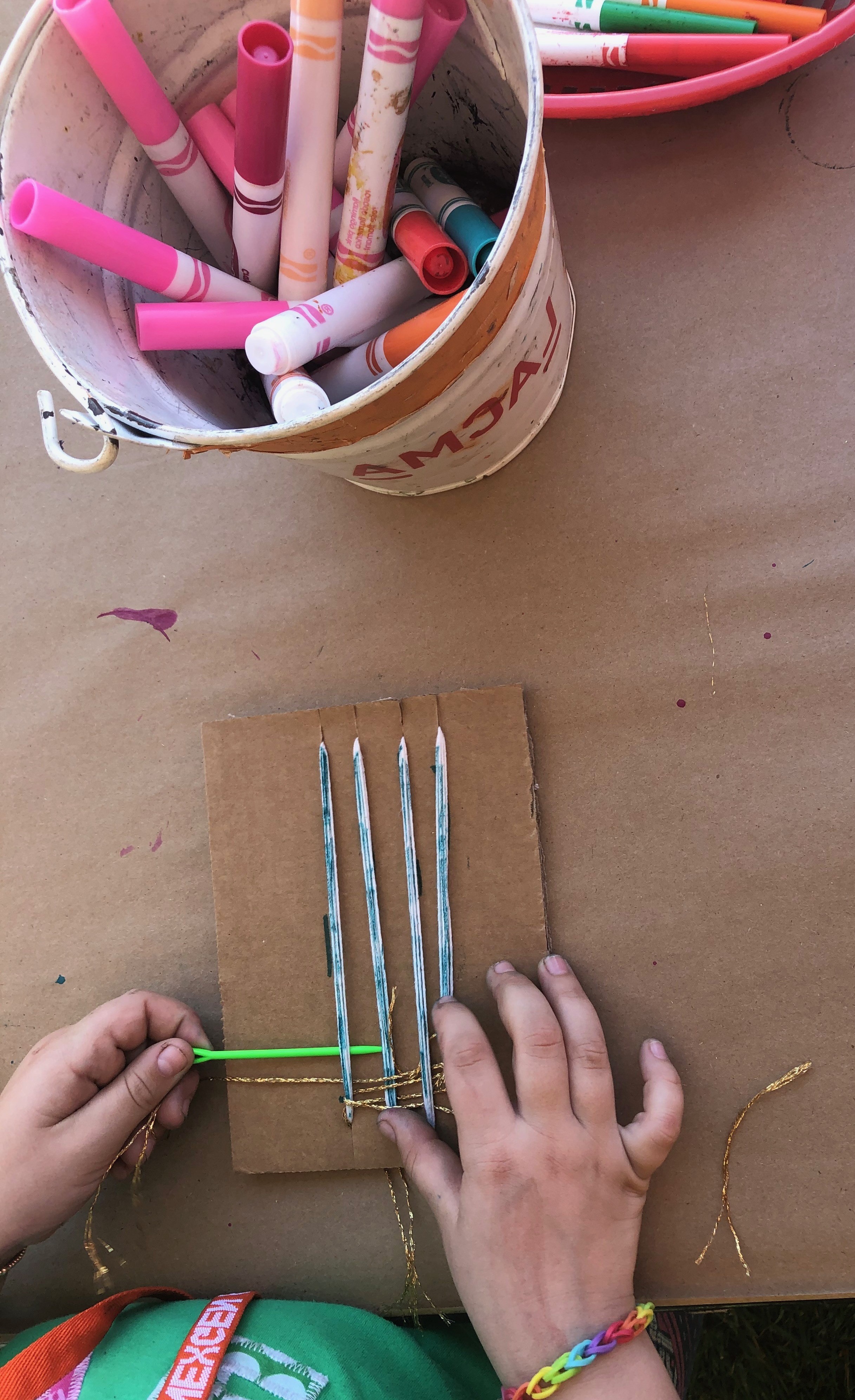 Child creating a weaving project in artist Julianna Ostrovsky's workshop