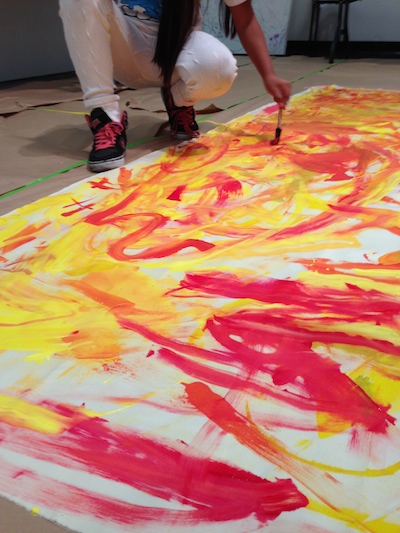 Student painting a canvas in the shape of a dumpster inspired by Oshiro’s piece Dumpster (Yellow with Blue Swoosh), 2010. Photo by Valentina Mogilevskaya