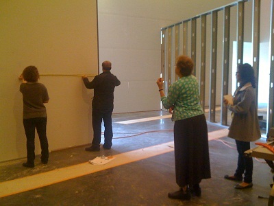 Curator Ilene Susan Fort, graphic designer Jin Son, exhibition designer Victoria Behner, environmental designer Daniel Young discussing the installation progress; Behner, Time Based Media Exhibition Manager Eddy Vajarakitipongse, curator Ilene Susan Fort and Curatorial Assistant Marvella Muro deciding where the exterior for the film should go