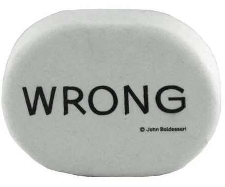 large, white, oval-shaped eraser with the word "WRONG" in bold, black, block letters across it