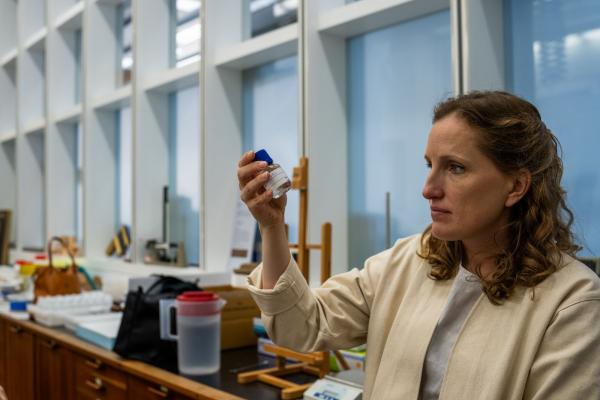 Photo of scientist holding a vial