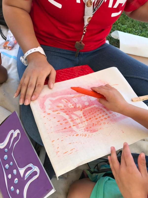 Toddler working on a pictograph rubbing in artist Eszter Delgado’s workshop