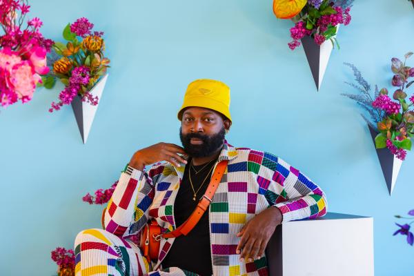 Maurice Harris sitting in a colorful floral installation