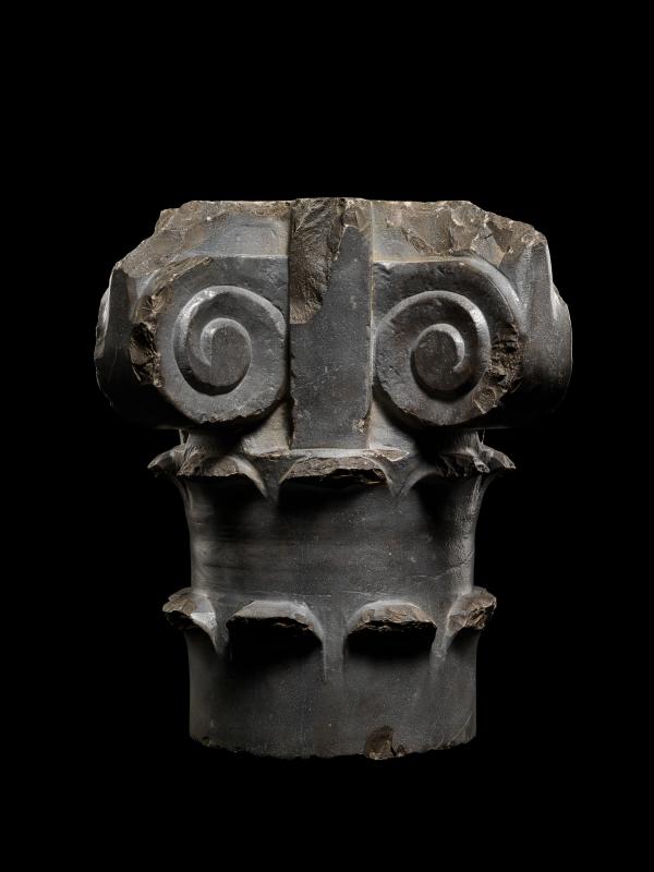 Stone column capital photographed on black background