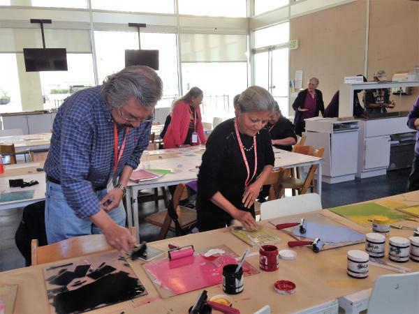 Create+Collaborate participants work side-by-side while inking their linoleum blocks.