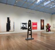 Gallery view with sculptures and paintings