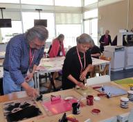 Create+Collaborate participants work side-by-side while inking their linoleum blocks.