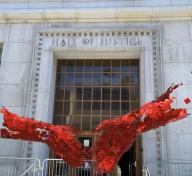 Augmented reality artwork of hands floating in front of building facade 